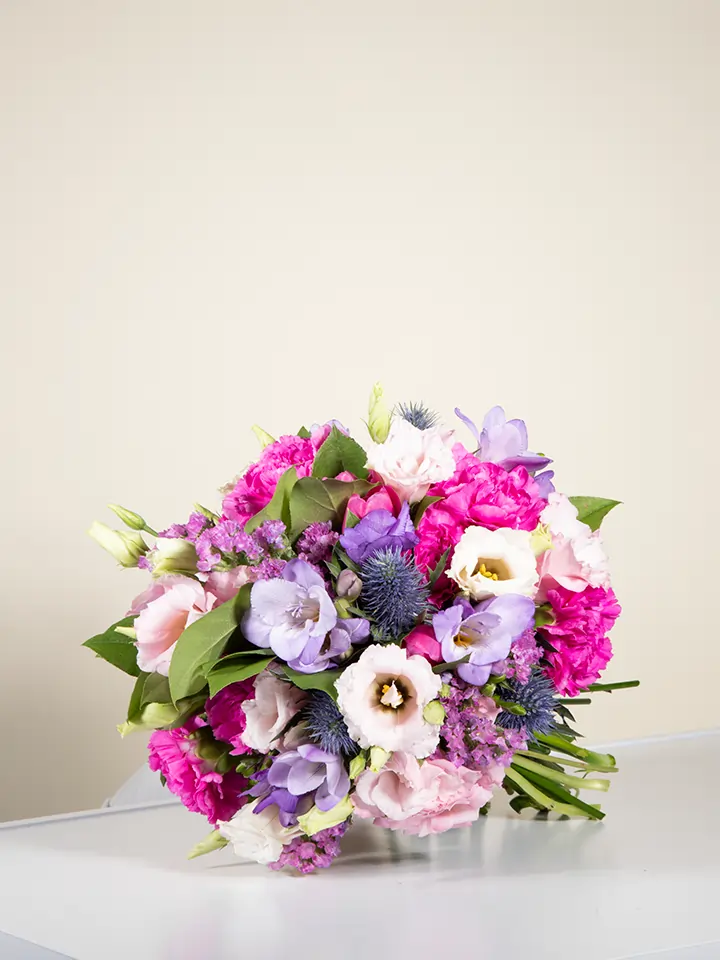 Bouquet viola lilla con lisianthus eryngium garofani in posa